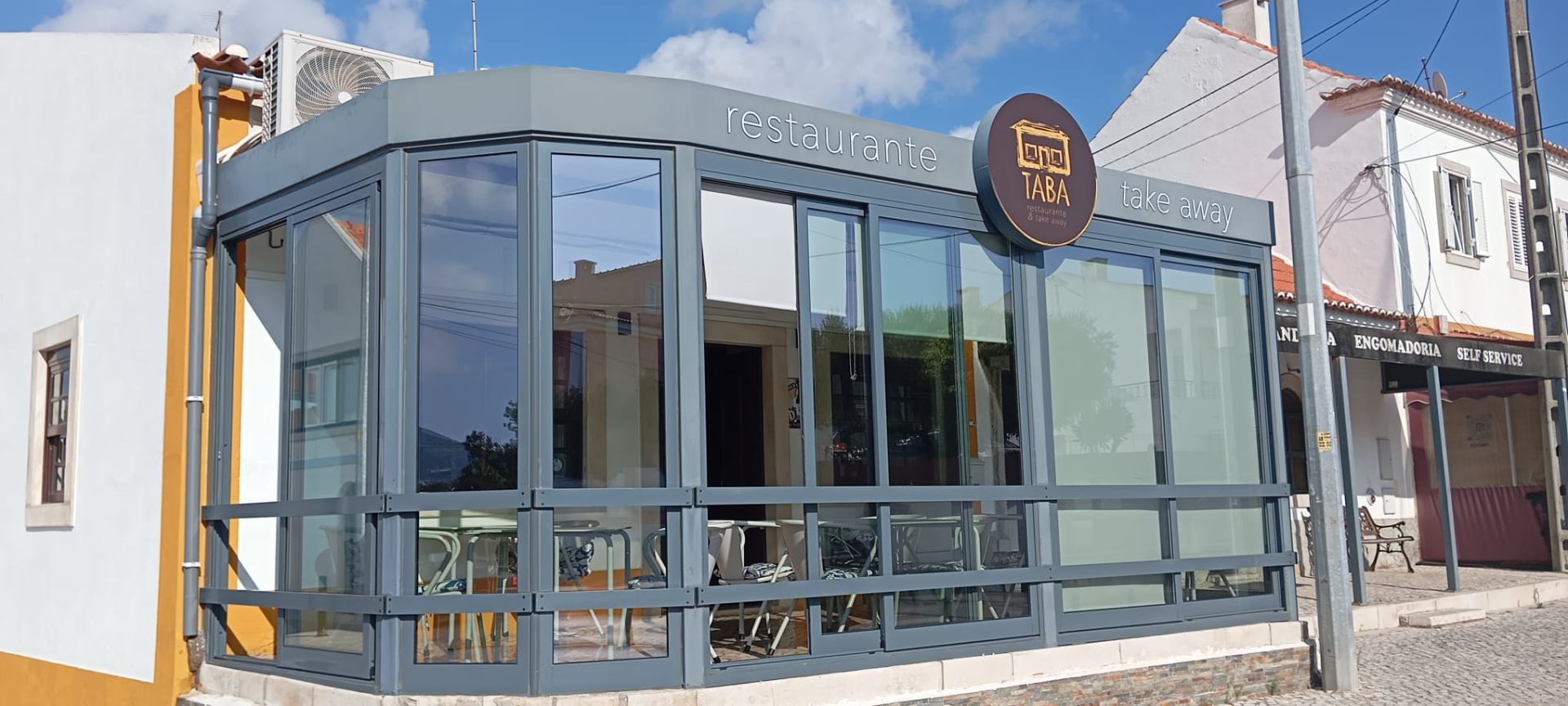 Fachada do Taba à noite, com a placa laranja do logótipo